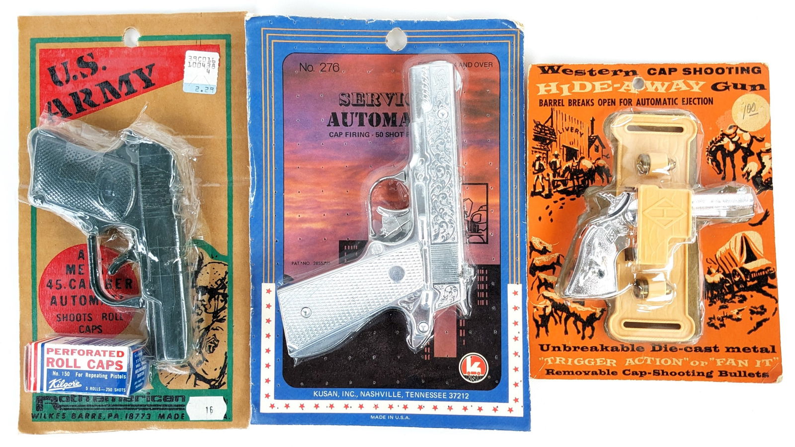 (3) Vintage Cap Guns In Original Packaging: Includes Leslie-Henry hide-away cap gun pistol, Leslie-Henry U.S. Army cap pistol with Kilgore roll caps, and Kusan automatic cap gun pistol. All are new in the package. The Army cap gun has tape on t