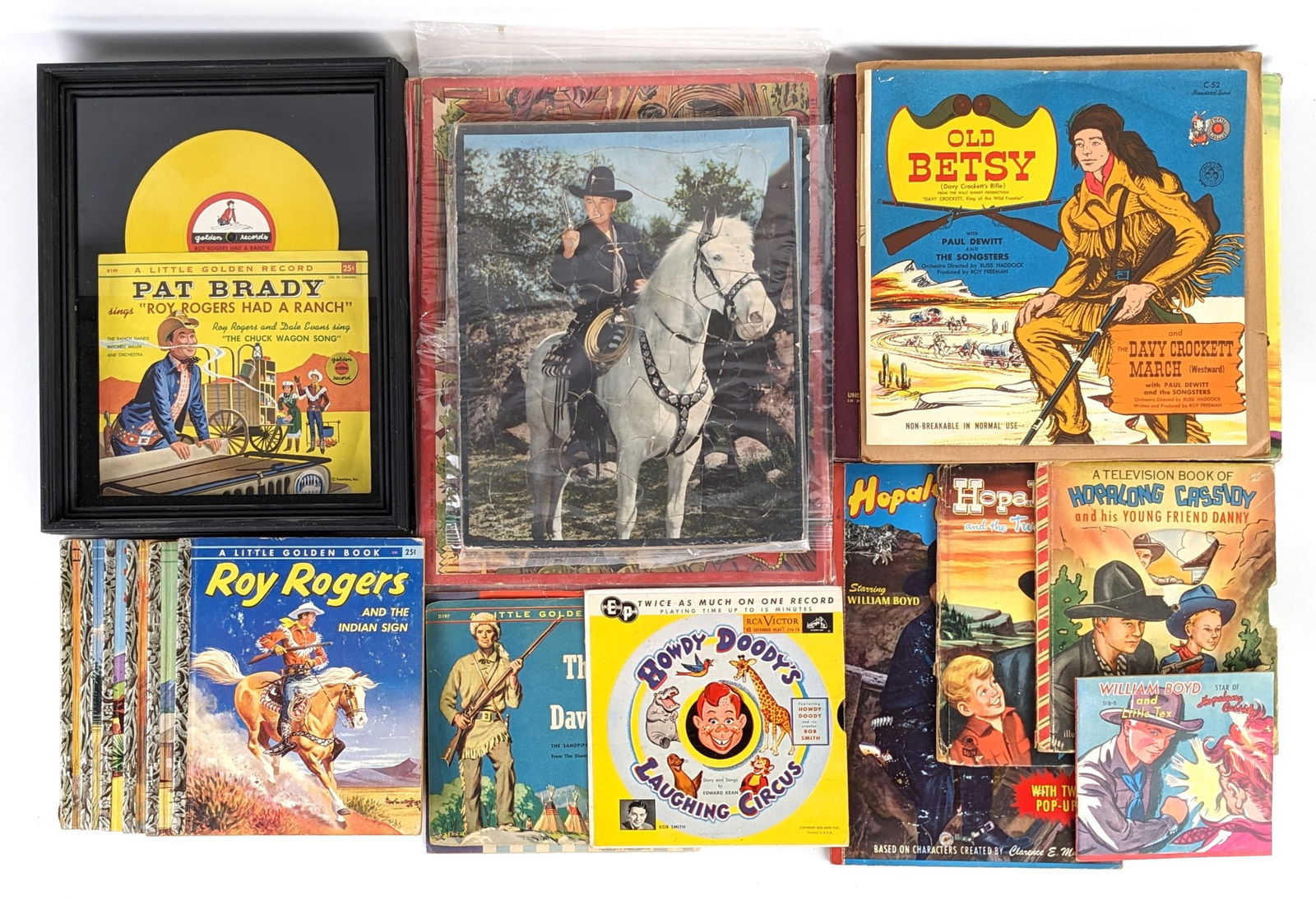 Western Cowboy Picture Puzzles, Records, & Books: Large lot of vintage western cowboy picture puzzles, records, and books. Includes Hopalong Cassidy and the singing bandit record reader, Howdy Doody 45 record, Old Betsy (Davy Crocket's Rifle) record,