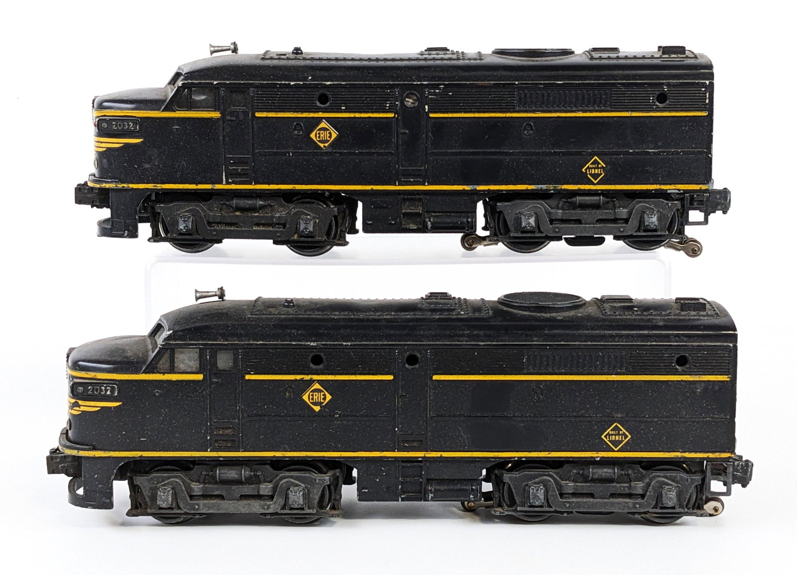 Lionel 2032 Erie Alco AA Diesel: Lionel #2032 Erie Alco AA powered and non-powered diesel units. Both show paint loss and wear from use / age. The powered unit is missing the battery cover.