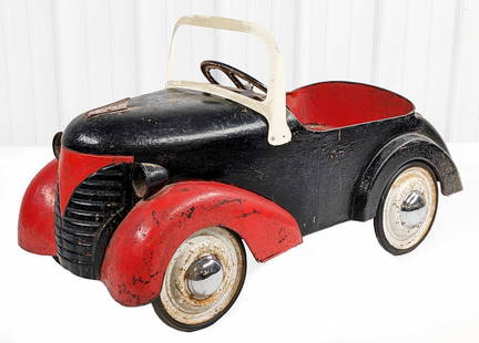 Garton Ford Pedal Car: Garton Ford pedal car. The car has an older overpaint and new chrome hubcaps. The car has surface rust, paint loss, and wear from age. Measures approximately 37" long.