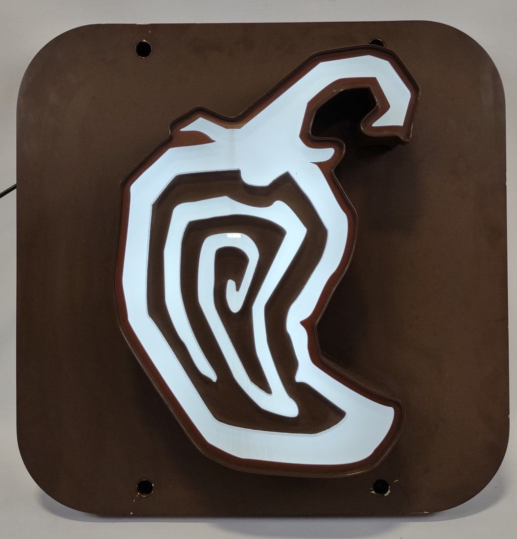 Chipotle Restaurant Lighted Advertising Sign: Original Chipotle Restaurant lighted advertising sign. It features a metal body with thick acrylic pepper face. Has paint loss and wear from use. Displays well. It measures approximately 27in tall by 