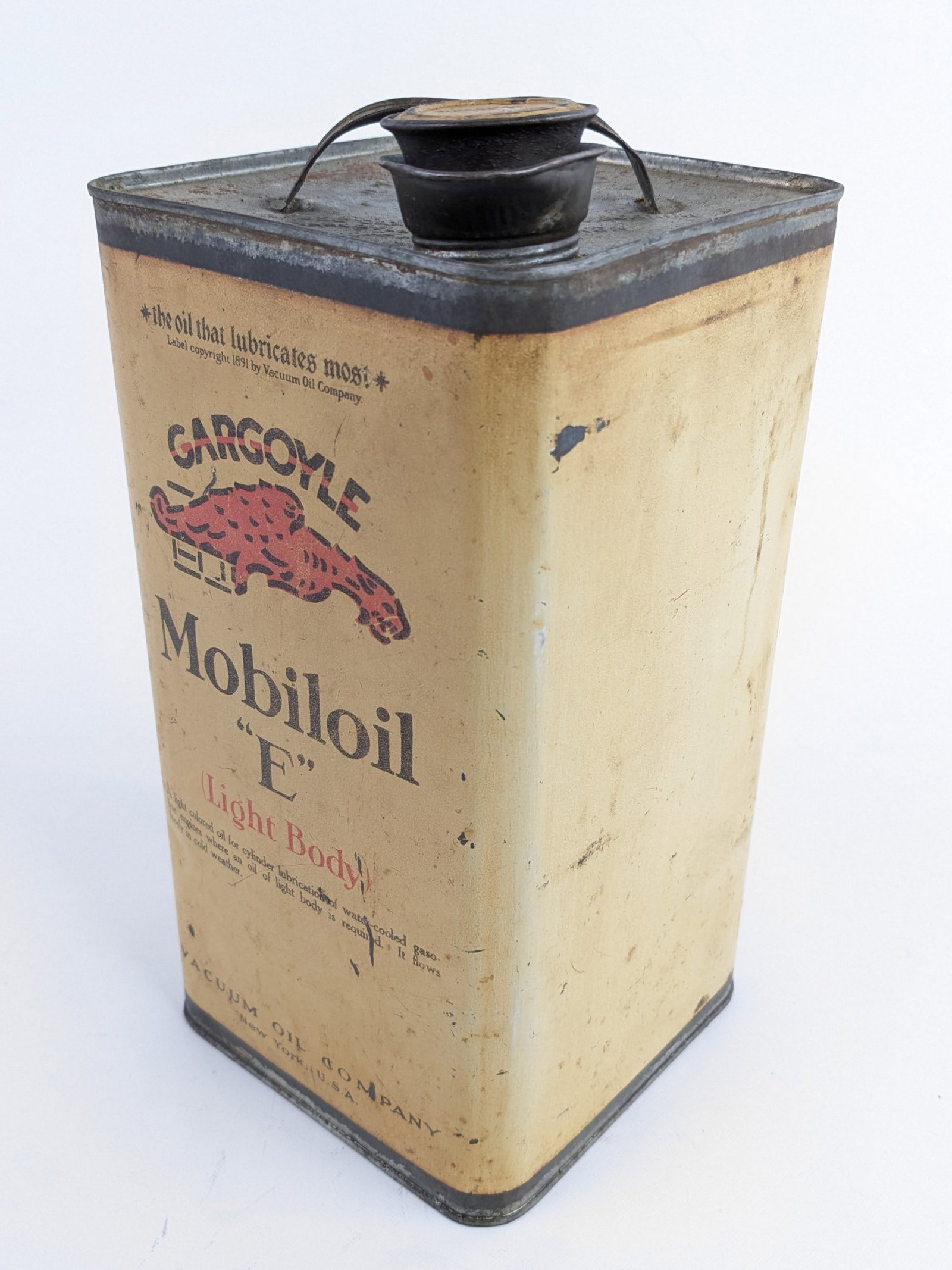 Early Mobiloil "E" Gargoyle 1 Gallon Can w/ Cap: Early Gargoyle Mobiloil "E" one gallon oil can with lid. Has paint loss, discoloration, scratches, and other wear form use and age. Displays well with Gargoyle graphic and patina.
