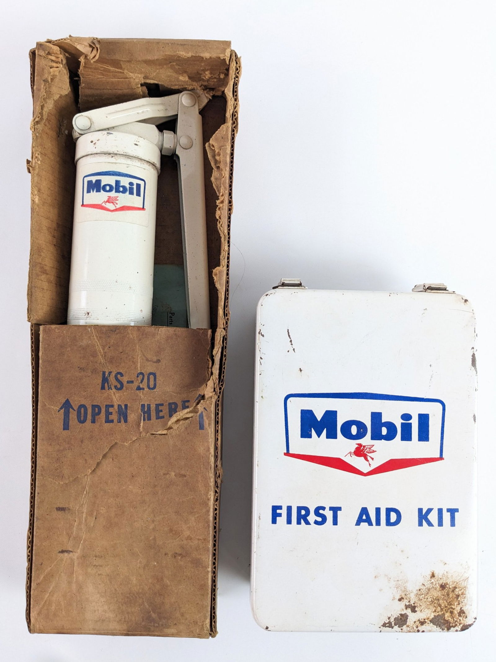Lot Of Vintage Mobil Service Station Items: Lot of vintage Mobil service station items. Lot includes a vintage giant grease gun in original box, and a Mobil metal first aid kit, and. Items vary in condition with wear from use and age. The greas