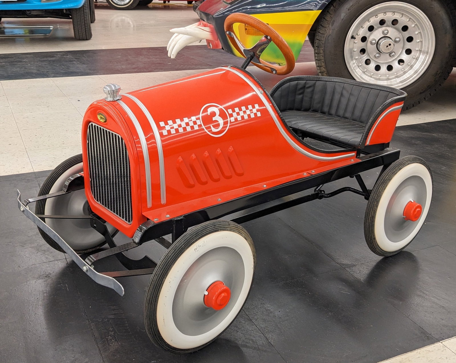 Contemporary No.3 Racer Pedal Car: Contemporary no.3 Racer metal pedal car. Nice condition with some scratches on the rims, discoloration, and other wear from display and storage. Measures approximately 36in across.