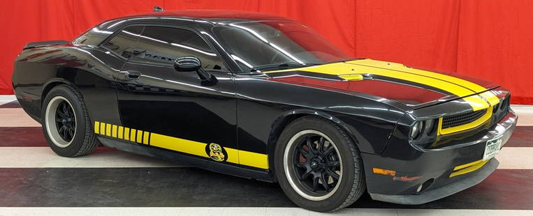 Cobra Kai 2009 Dodge Challenger R/T: Car has the yellow racing striped and Cobra Kai emblems on the sides and the top of the trunk. There is a dent on the driver's side door and some other general wear from use and age.? Motor: 3.5L V6 G