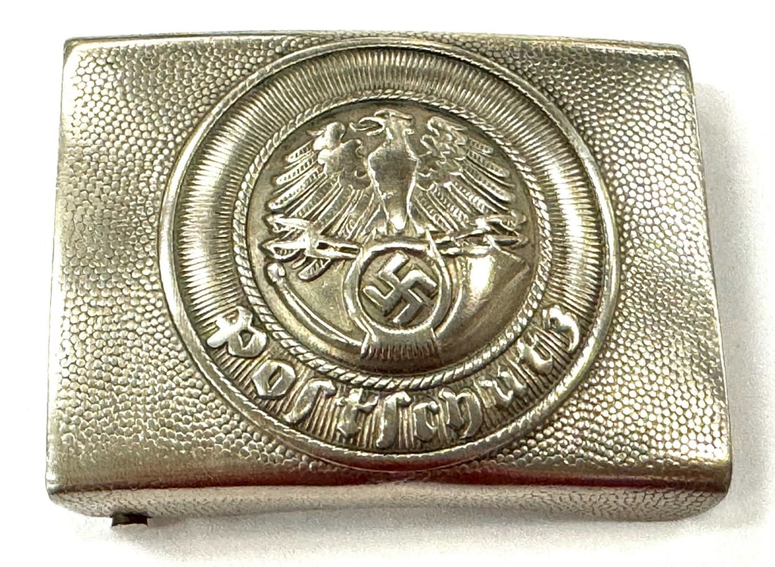 German WW2 Postschutz Belt Buckle: German WW2 Postschutz (Postal Protection) Belt Buckle. Belt Buckle is made out of nickel silver and is in overall good condition has some green staining on sides. Measures 2 1/2" x 1 3/4"