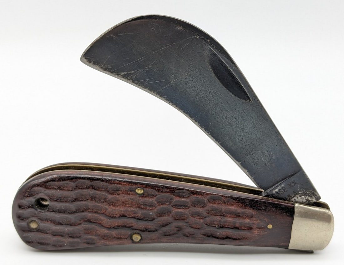 1974 Case XX Jig Wood Hawkbill 61011: Knife is in fair condition with a blued finish on the blade with scratches and some pitting, scuffs and dings on the bolsters, and light wear on the handle scales. Overall measures 4in when closed.