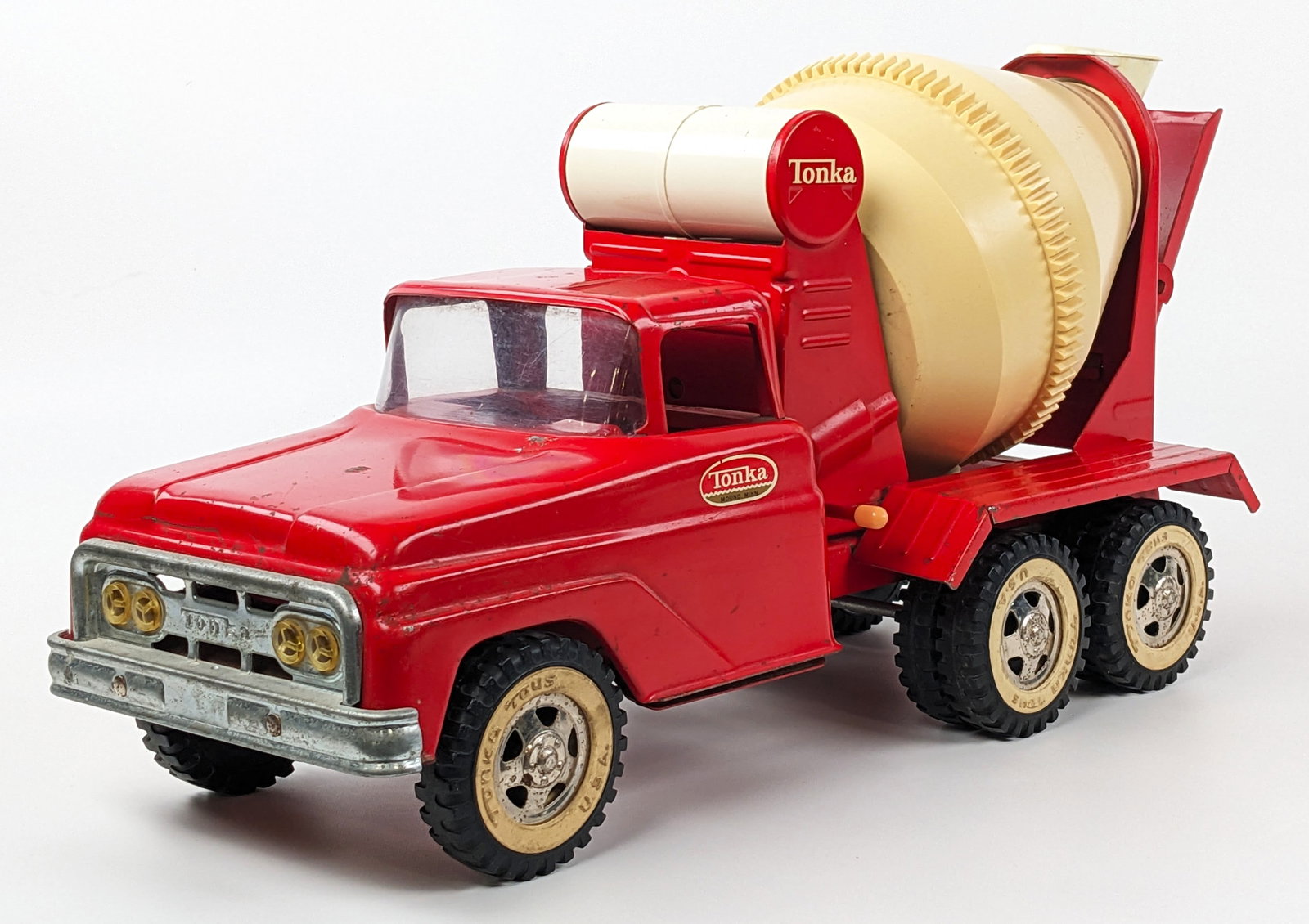 Original Tonka Cement Mixer Truck: Original Tonka cement mixer truck. The truck has some yellowing to the mixer drum, paint loss, and wear from age. The mixer spins with the front wheels. Measures approximately 16" long.