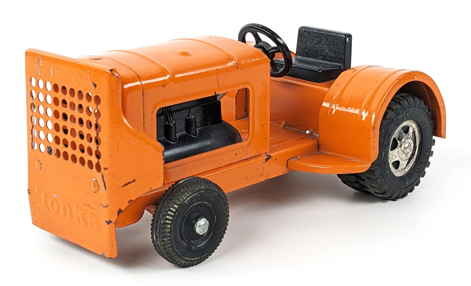 Original Tonka Orange Luggage Service Tug / Tractor: Hard to find original Tonka luggage service tug / tractor. Orange is much harder to find than the common blue tug. It has some paint loss and wear from play / age. Measures approximately 8-1/2" long.