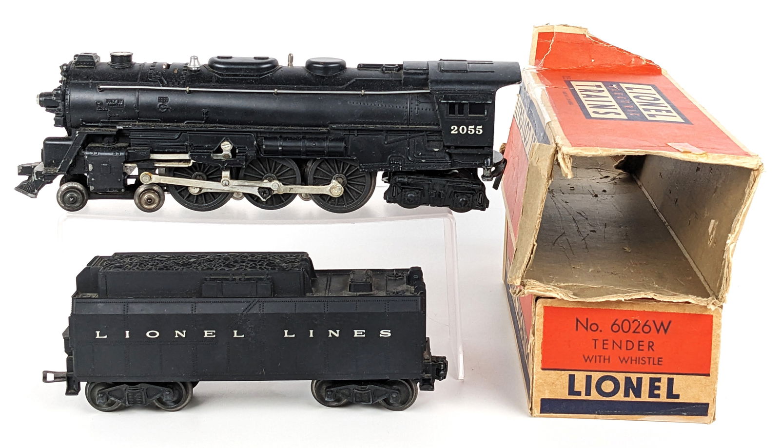 Lionel 2055 Locomotive and 6026W Tender: Lionel 2055 locomotive with 6026W tender. Both come with original boxes. Both boxes missing end flaps, have tape, and showing wear from age. The enging and tender show some light paint loss and wear f