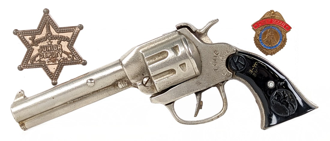 Kilgore Cast Iron Lone Ranger Cap Gun w/ Badge: Kilgore cast iron Lone Ranger cap gun with Lone Ranger badges. The gun has a chip out of the one grip and use wear on the inside of the gun. Measures 8" long.