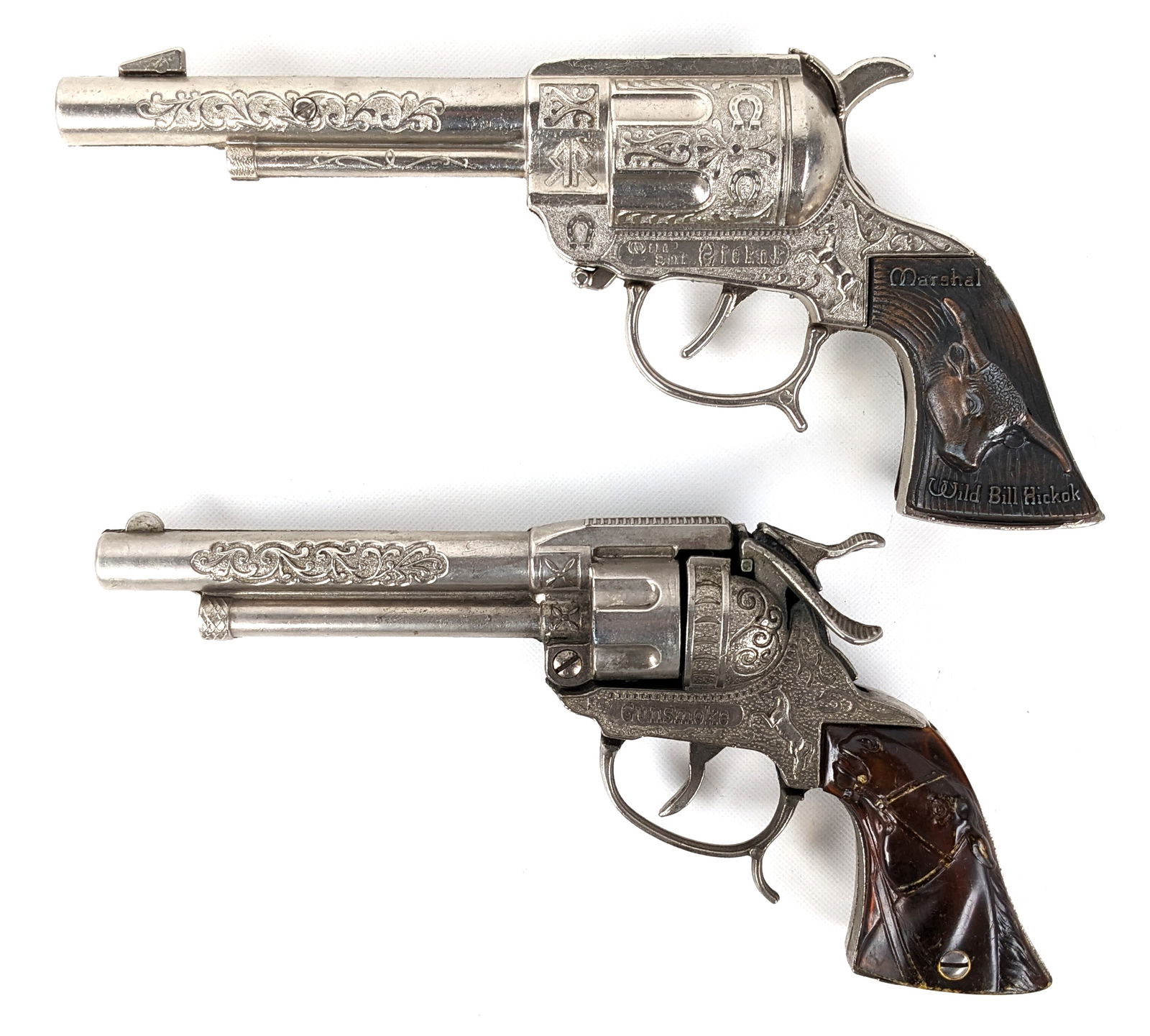 Marshal Wild Bill Hickok & Gunsmoke Cap Gun: Includes Wild Bill Hickok cap gun and Gunsmoke cap gun. Both have light wear from use / age. Largest measures 9-1/2" long.