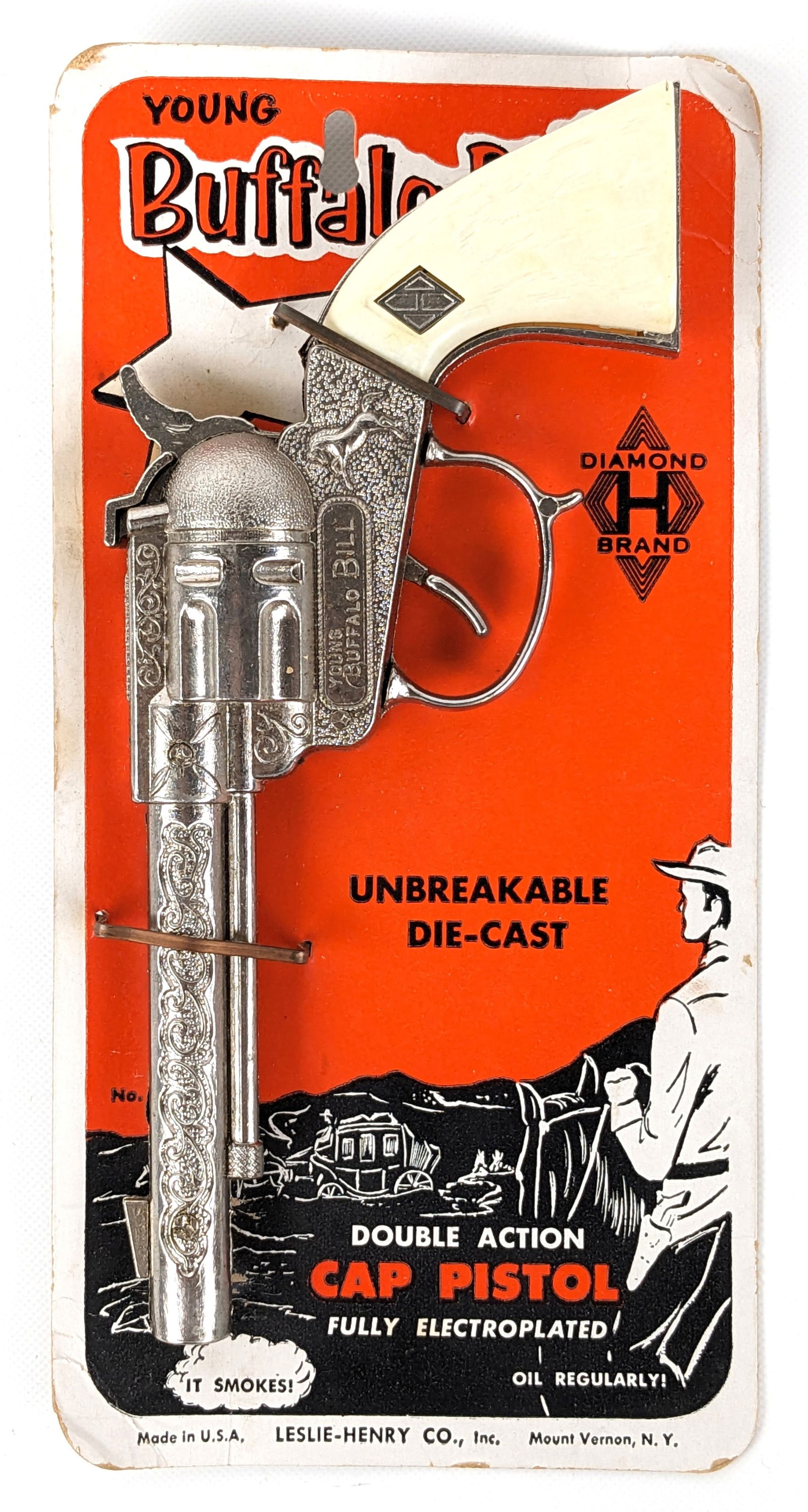 Leslie-Henry Young Buffalo Bill Cap Gun In Package: Leslie-Henry Young Buffalo Bill cap gun in the original package. The package has some creasing and light wear. The one grip on the gun is loose. The gun appears to be unfired. Measures 8" long.