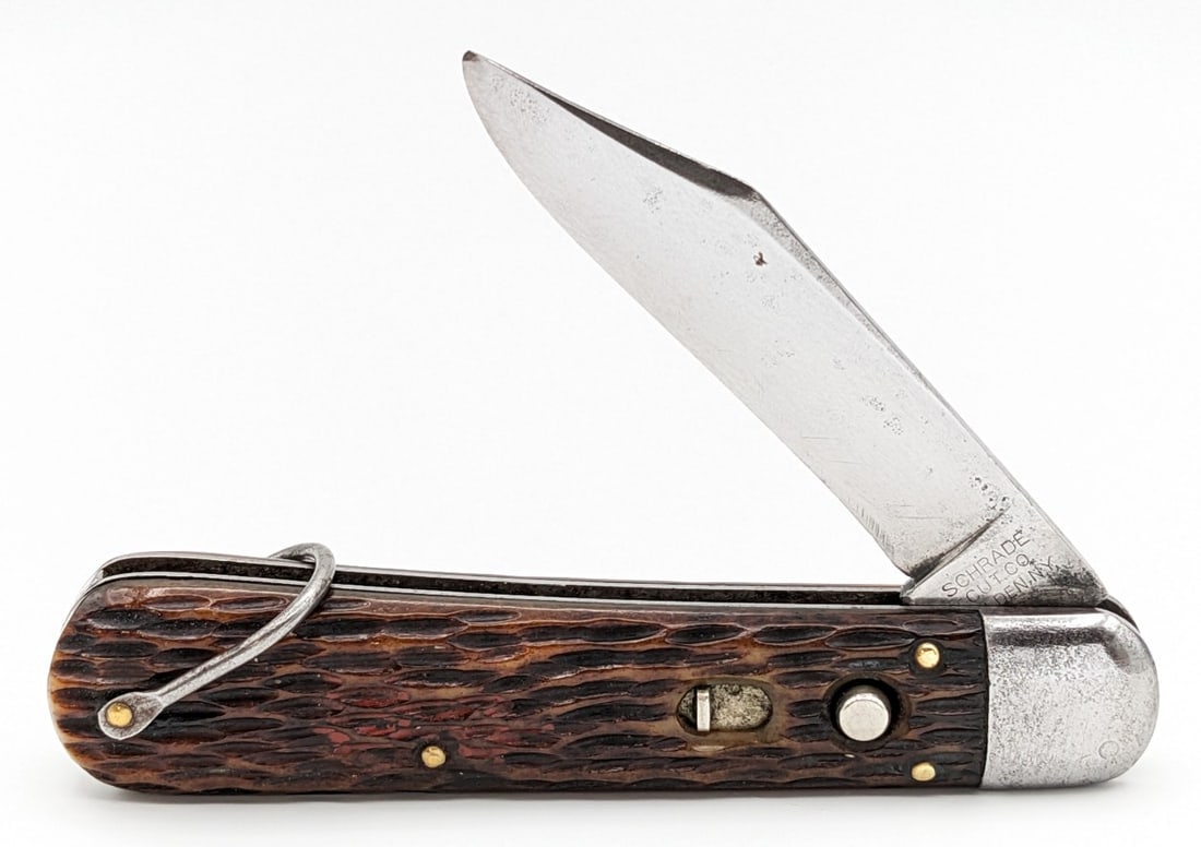 Schrade Cut Co. Jigged Bone Switchblade Knife: Knife is in good used condition with scratches and material loss on the blade, scuffs and pitting on the bolsters, and very nice handle scales. Knife has a strong spring, and has a good bit of play wh