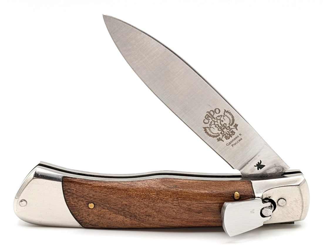 Russian Capo Smooth Wood Leverlock Switchblade: Knife is in nice condition with minimal wear on the blade, and some scuffs and dings on the bolsters. Knife has a strong spring, and locks tight when open. Overall measures 4-1/2in when closed.