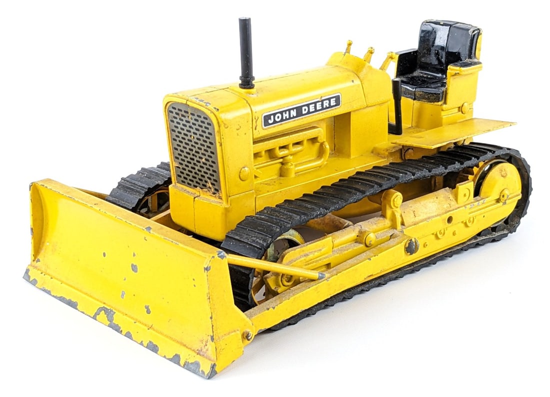 1/16 Ertl John Deere 1010 Industrial Crawler w/ Blade: 1/16 Ertl John Deere 1010 industrial crawler with blade. The crawler is in original condition with paint loss and wear from play / age.