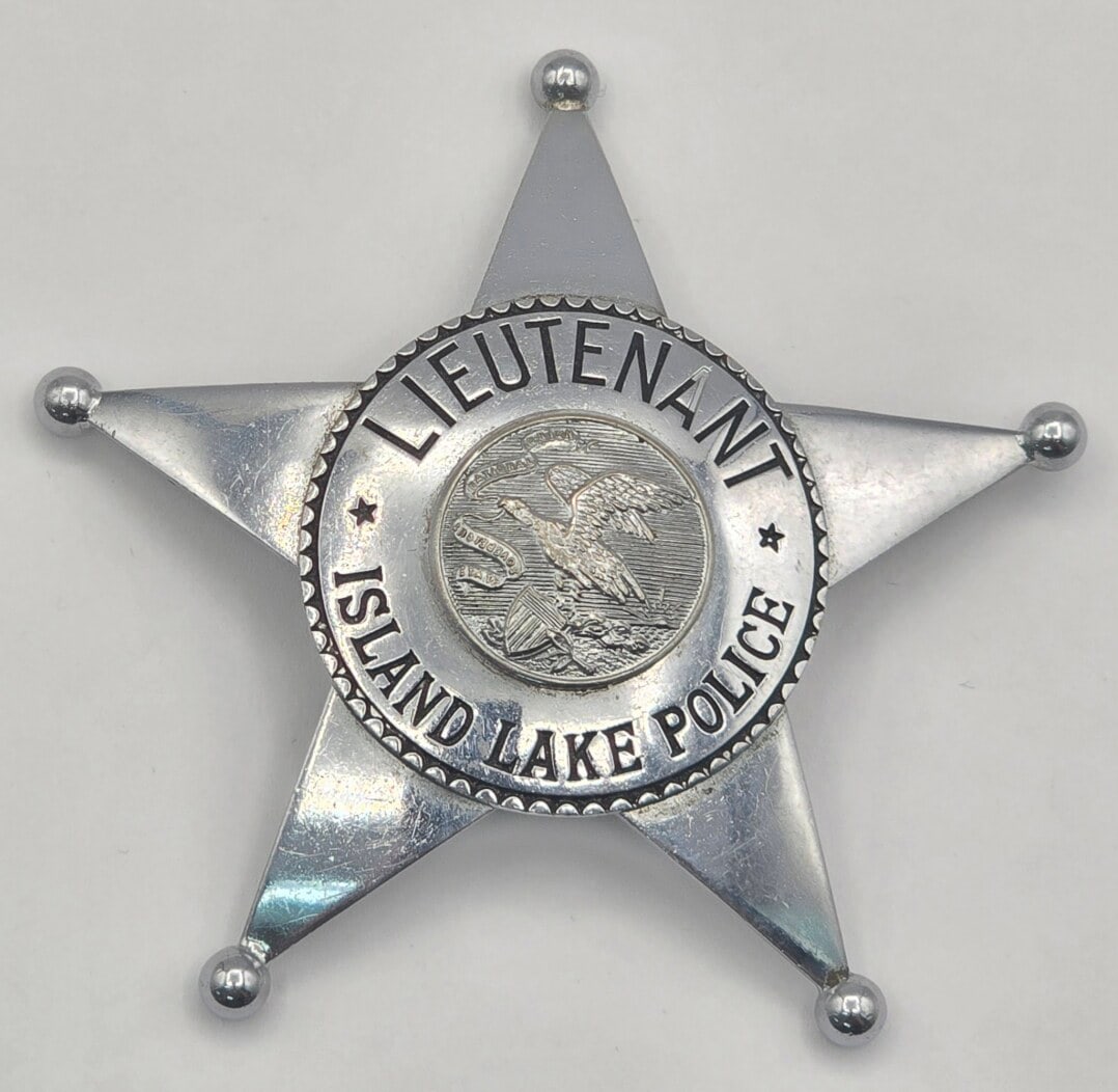 Obsolete C.H. Hanson Island Lake Illinois Police Lieutenant Star Badge: Obsolete Island Lake, Illinois Police Lieutenant 5-Point Star Badge with ball tips. Badge is in nice condition with a pin back, has some age and use wear. Maker marked C.H. Hanson. It measures approxi