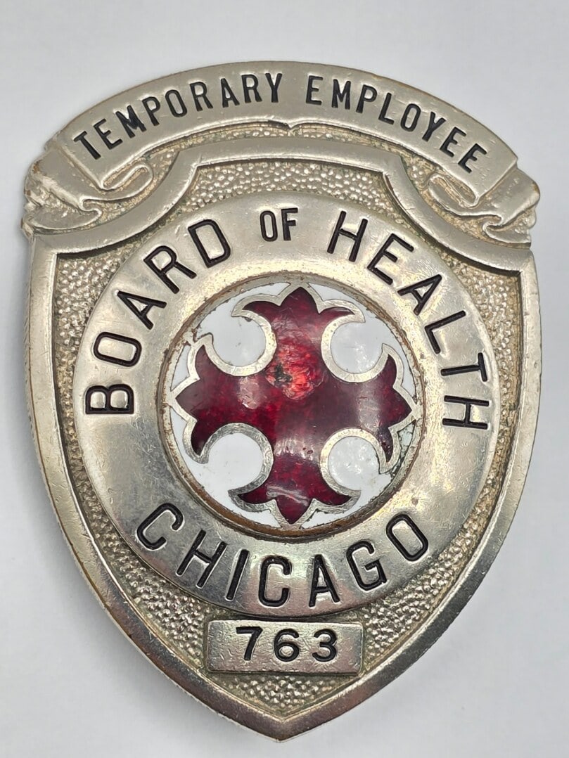Obsolete C.H. Hanson Chicago Board Of Health Temporary Employee Shield Badge #763: Obsolete Chicago Board Of Health Temporary Employee Shield Badge #763. Badge is in nice condition with a pin back, has some age and use wear with a chip in the enamel. Maker marked C.H. Hanson Chicago