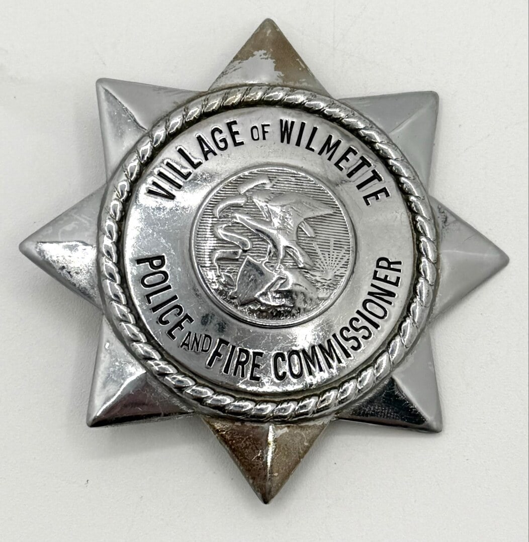 Obsolete Named Wilmette Illinois Police & Fire Commissioner Star Badge: Obsolete Village Of Wilmette Illinois Police & Fire Commissioner 8-Point Star Badge. The badge has a pin back with some light age and use wear. No maker mark. Badge measures approximately 3" tall by 3