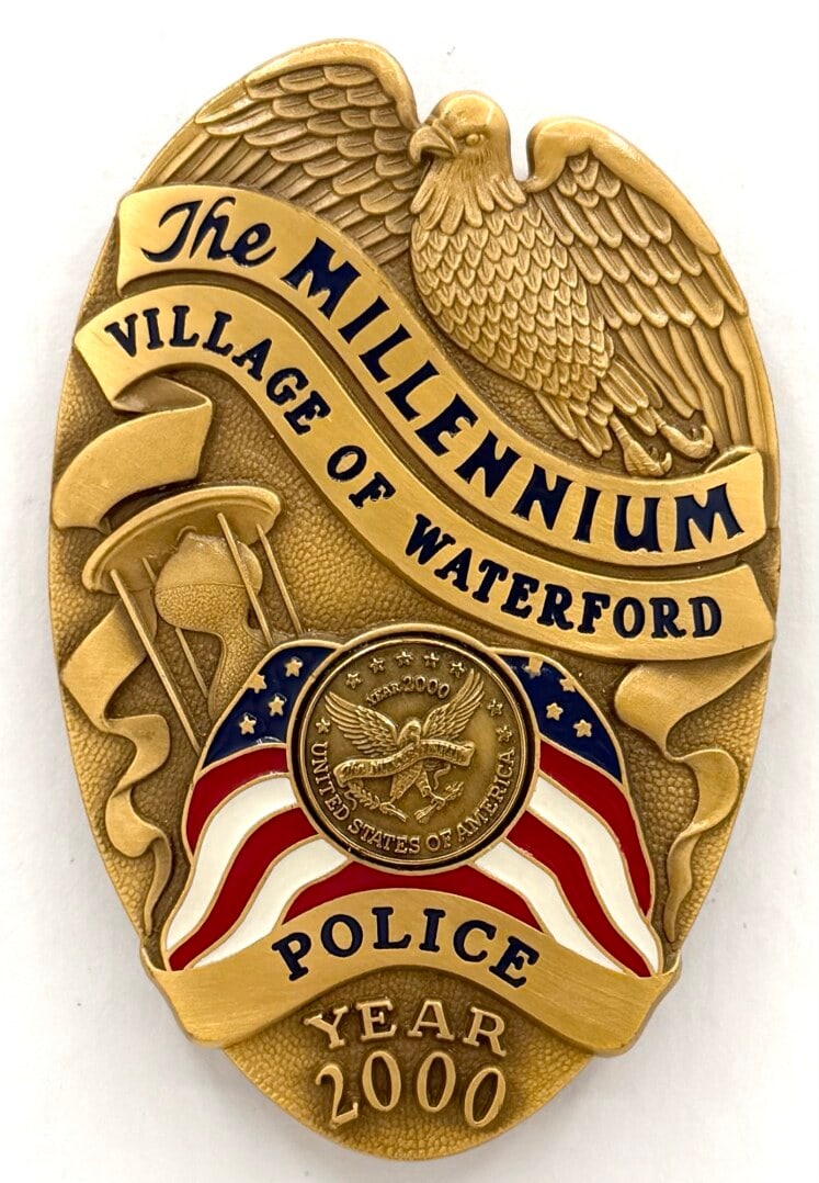 Obsolete 2000 Village Of Waterford Police Millenium Badge: Obsolete 2000 Village Of Waterford Police Millennium Shield Badge. The badge has a pin back with little age and use wear. Maker marked Collinson. Badge measures approximately 3-3/8" tall x 2-1/4" acro