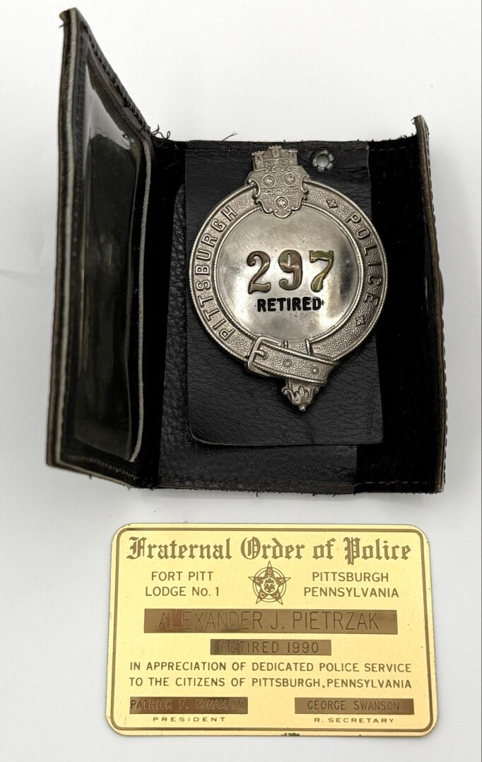 Obsolete Pittsburgh Police Retired Badge #297 In Leather Wallet: Obsolete Pittsburgh Police Retired Badge in leather wallet with FOP card. The badge is in good condition with pinback. No maker mark. Badge measures approximately 3-1/4" tall by 2-5/8" across.