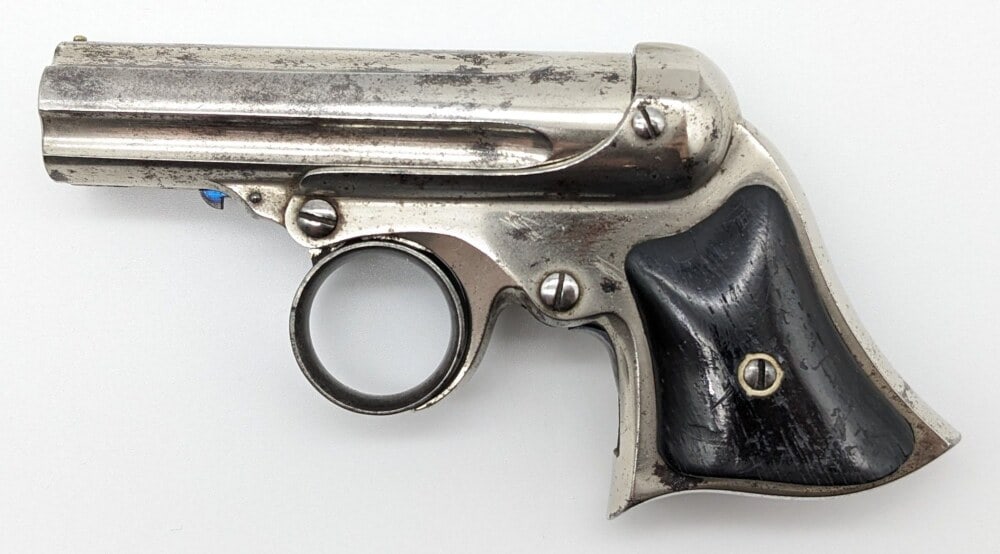 Remington Elliot .22 Cal Ring Trigger 5-Barrel Derringer: Manufacturer: Remington & Sons, Model: Ring Trigger, Type: Derringer, Caliber/Gauge: .22 Cal, Barrel: 3 inch, Choke: , Finish: Nickel, Grip: Smooth Wood, Stock: , Condition: Good with some splotchy fi