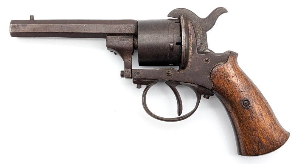 Belgian 9mm Pinfire Revolver: Manufacturer: Belgium, Model: Pinfire, Type: Revolver, Caliber/Gauge: 9mm Pinfire, Barrel: 4 inch Octagon, Choke: , Finish: Oxidized Blue, Grip: Smooth Wood, Stock: , Condition: Aged with missing part