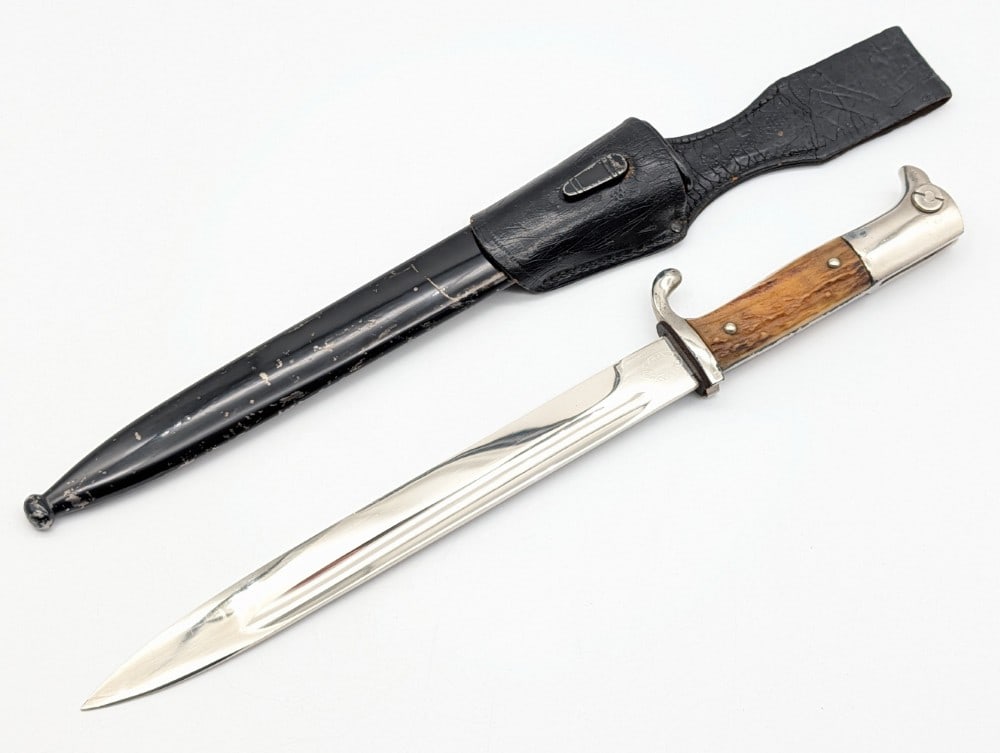 WWII German F.W. Holler Stag Dress Bayonet w/ Scabbard & Frog: Features a nickel plated blade, nickel plated guard, stag handle scales, the original red felt in the bayonet channel, and a nickel plated eagles head pommel. Bayonet is in nice condition with some sc