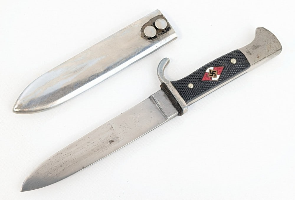 WWII German 1939 J.A. Henckles RZM M7/10 Hitler Youth Knife w/ Scabbard: Features a polished blade stamped with the Henckles stamp and RZM marking, black checkered plastic handle scales, and nickel guard and pommel. Knife is in fair cleaned condition with material loss on