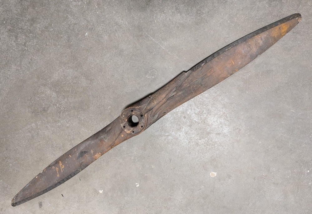 WWII Battle Worn Sensenich Bros Airplane Propeller: Propeller is heavily cracked and seems like it was burned giving it unique character. Measures 5-1/2ft long.