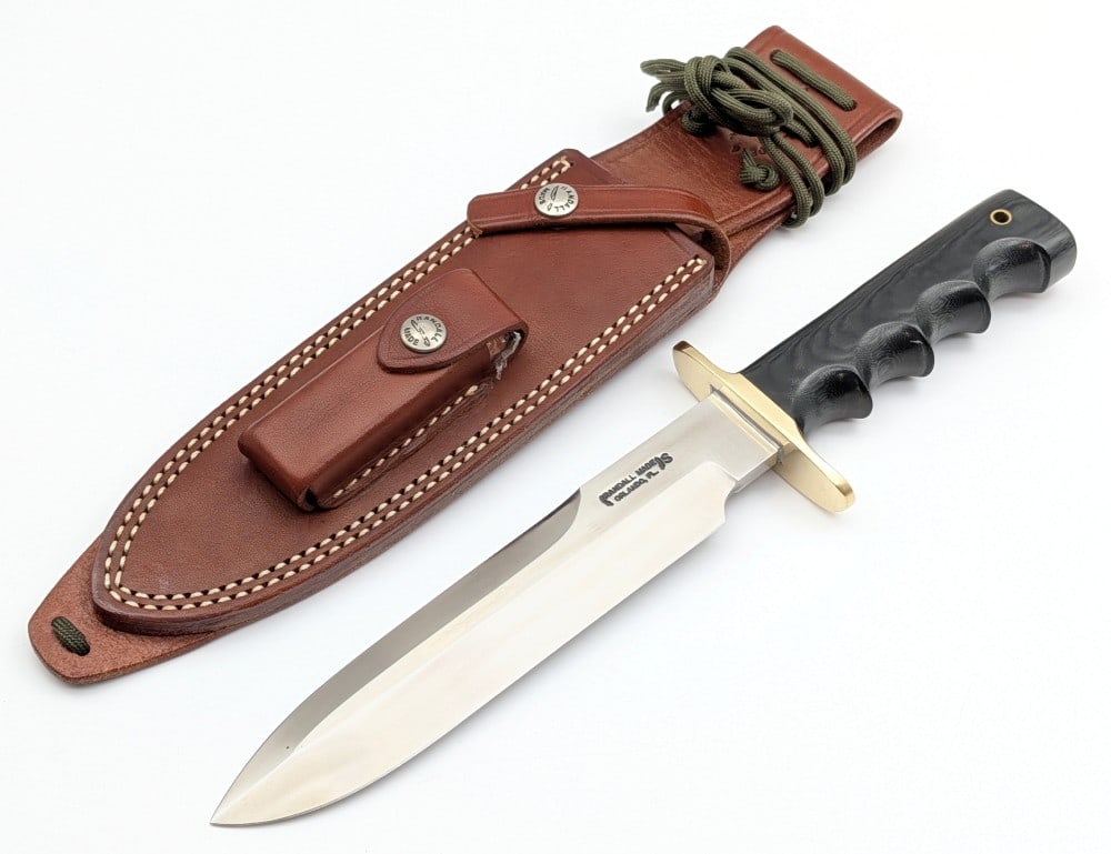 Randall Model 14 Teeth NO TEETH Double Edge Grind Attack Knife w/ Sheath: Features a stainless steel blade, Teeth No Teeth Double Edge Grind, brass double downturned guard, full tang handle construction, and a finger groove black micarta handle with a lanyard hole. Knife is