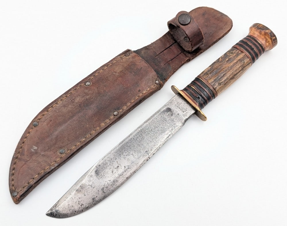 1910-16 Marble's Stag on Stag Ideal Hunting Knife w/ Case Tested Sheath: Features a brass double guard, stag handle scales with 24 brass black and red spacers, and a large stag pommel with a large brass nut. Knife is in good aged condition pitting and carbon spots on the b