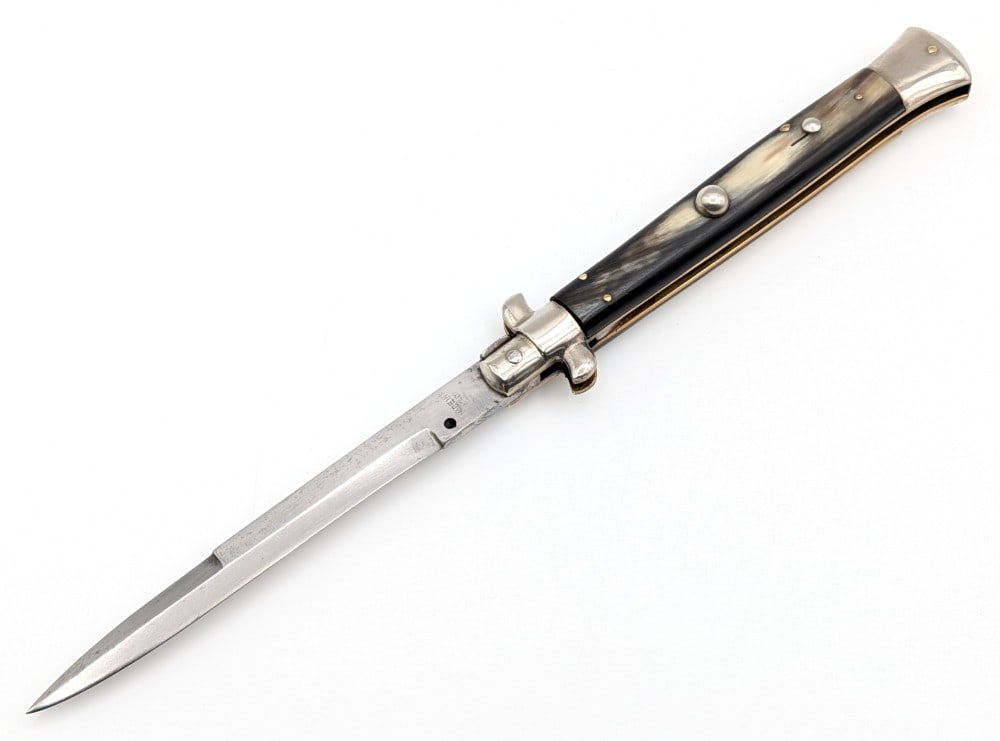 11in Italian Horn Handle Pick Lock Switchblade: Features a stainless steel guard and bolster, and horn handle scales. Knife is in good used condition with some material loss and scratches on the blade, scuffs and tarnishing on the guard and bolster