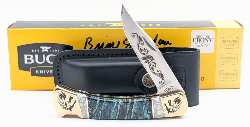 Buck Custom 110 Brian Yellowhorse Mammoth Tooth Lock Back w/ Sheath & Box: Features horse etching on the blade, matching horse engraving on the bolsters, and dyes mammoth tooth handle scales with natural stone accents. Knife is in like new condition. Overall measures 4-7/8in