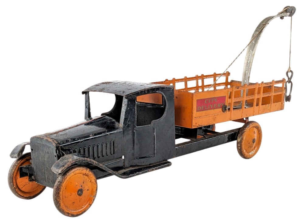 Steelcraft City Delivery Truck: Steelcraft City Delivery stake bed truck. the tow boom appears to be a period custom that was added to the truck. The truck has paint loss, surface rust, and wear from play and age. All original