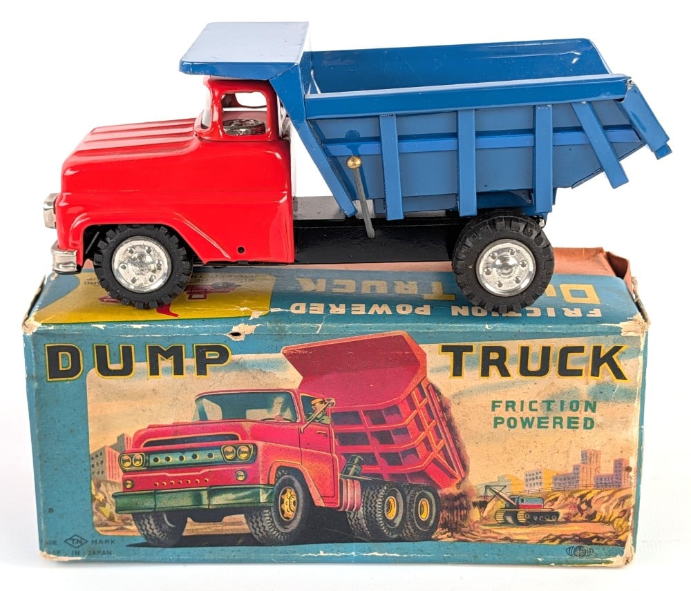 Japan Tin Friction Dump Truck w/ Box: Japan tin friction dump truck with the original box. The friction drive works. The toy has a box rub on the top of the dump bed. The box has some punctures and edge wear. Displays well with great