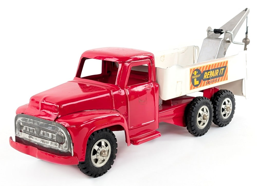 Buddy L Repair It Service Wrecker Tow Truck: Buddy L Repair It service wrecker tow truck. The truck is original with a nice replacement boom. The truck has some paint loss and wear from play and age. Measures approximately 24" long.
