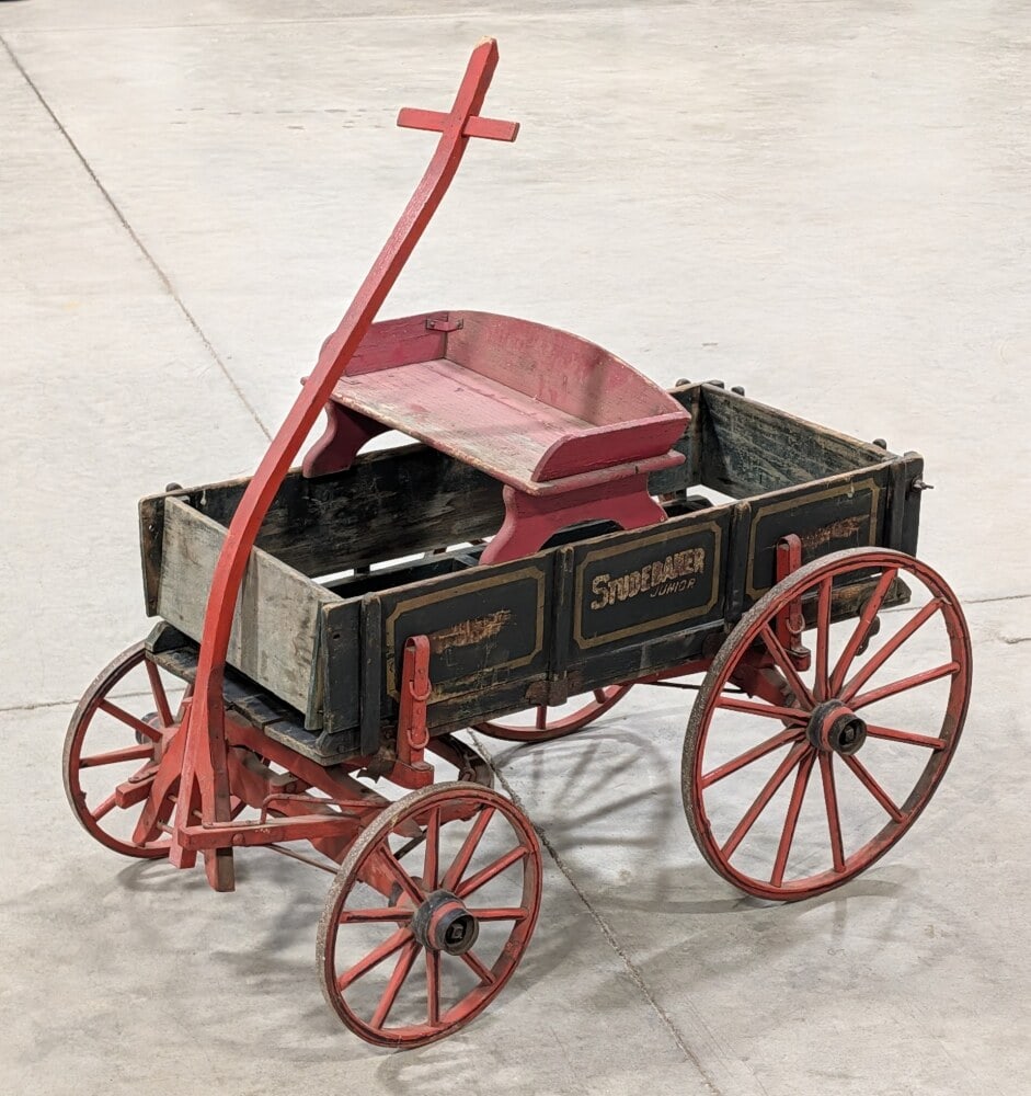 Studebaker Junior Goat Wagon: Studebaker Junior goat wagon. The wagon has paint loss, discoloration, and wear from age. The wagon displays well with Studebaker Junior stenciling. Measures approximately 41" long without the handle.