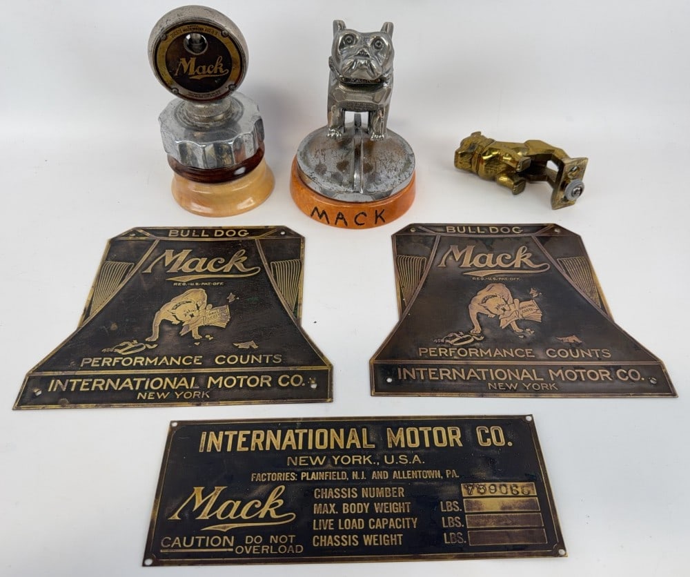 Lot of Mack Truck Hood Ornaments and Brass Tags: Mack Boyce Moto-meter on a wood base. Large Mack bulldog truck mascot, said to be from a 1932 truck, measures 6.5? tall. Smaller Mack bulldog, measures 4? tall. Mack International Motor Co. brass
