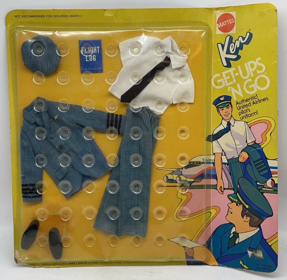 1973 Mattel Ken Get-Ups 'N Go United Airlines Pilot's Uniform in Package: The package has wear on the edges and corners and a fold by the plastic bubble. There is a crack in the bubble along the bottom.