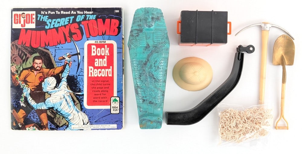 Vintage Hasbro GI Joe Mummy's Tomb Accessories: Vintage Hasbro GI Joe Mummy's Tomb accessories. Includes mummy's tomb, pickaxe, shovel, net, hat, and Mummy's Tomb book. The book is missing the record. Items show some wear from play and age.