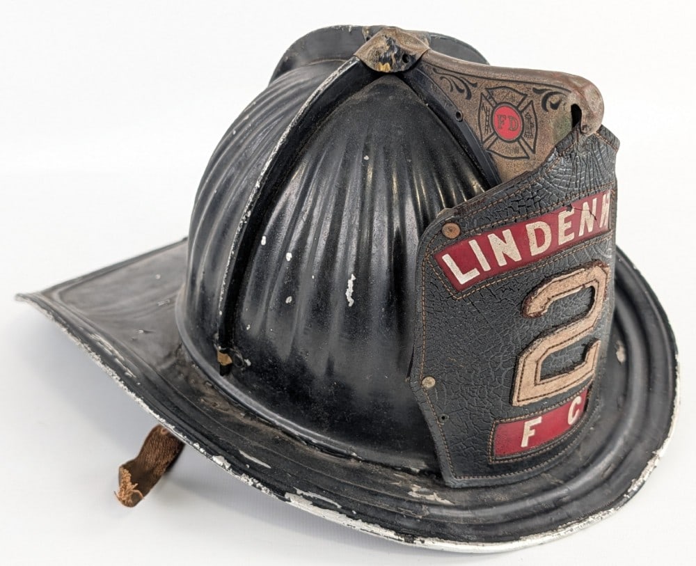 Early Cairns & Brother Metal Lindenwold Fire Helmet w/ Leather Badge: Early Cairns & Brother Lindenwold Fire Department fireman's helmet with leather badge. Has paint loss, plate loss on eagle, weathering to leather badge, missing some of the badges mounting pins,