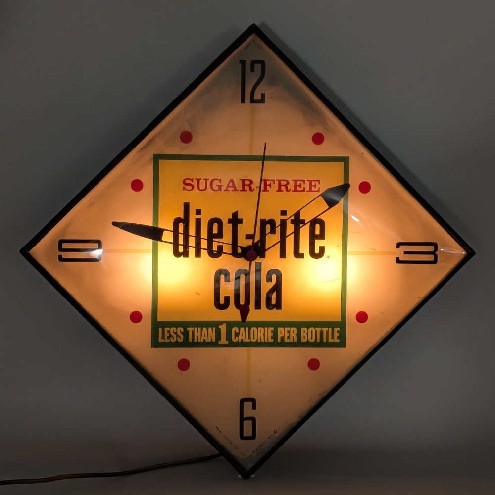 Vintage Diet-Rite Cola Lighted Advertising PAM Clock: Vintage Diet-Rite Cola lighted advertising pam clock. The clock has some scratches to the face, oxidation to the metal ring, scratches around the mounting hole, and wear from use and age. The clock li