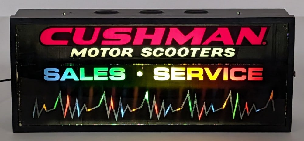 Vintage Cushman Motor Scooters Sales & Service Lighted Advertising Sign: Vintage Cushman Motor Scooters Sales & Service lighted advertising sign. The sign lights up and works as it should. It does have some rub marks to the sign face and scratches to the metal can. Measure