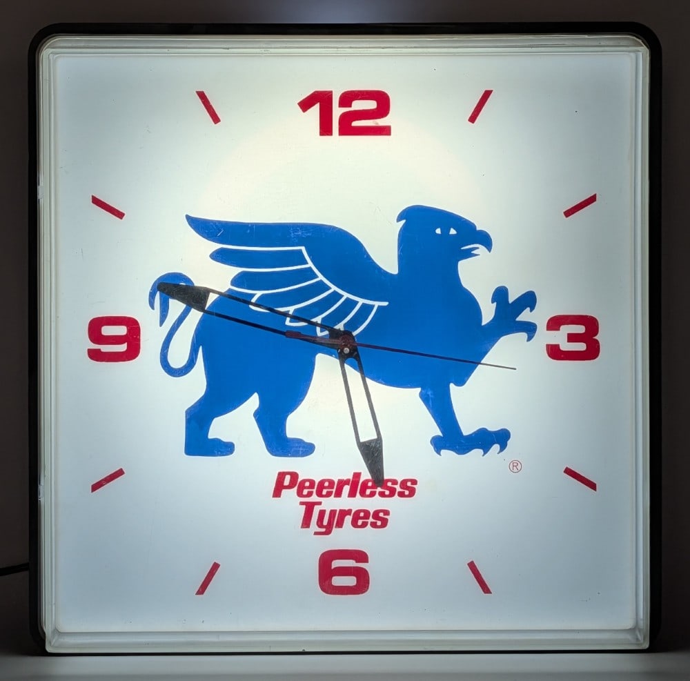 Vintage Peerless Tyres Lighted Advertising Clock: Vintage Peerless Tyres lighted advertising clock. The clock lights up, but is currently not running. The clock has some scratches and light wear from handling and display. Measures approximately 16"