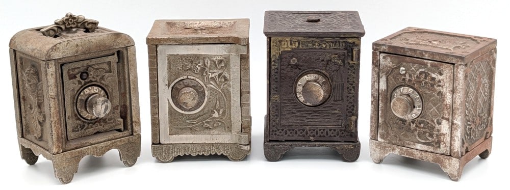 (4) Cast Iron Ornate Still Safe Banks: (4) Cast iron ornate still safe banks. The banks show plating loss, discoloration, surface rust, and wear from use and age. No combinations included. Largest measures approximately 4-1/4" tall.