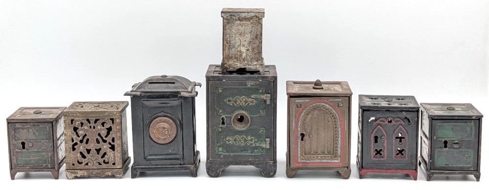 (8) Cast Iron & Pressed Steel Safe Still Banks: (8) Cast iron and pressed steel safe banks. The banks show paint loss and wear from use and age. Largest measures 4-1/4" tall.