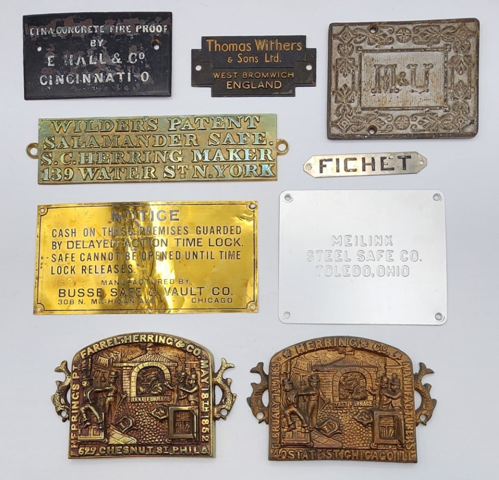 9 Cast Metal Safe Door Plaques: Safe brands include Thomas Withers & Sons Ltd, Busse Safe & Vault Co, E. Hall & Co and more. Metal is worn due to age and handling with small scuffs in paint. Biggest plaque measures 8" X 4"