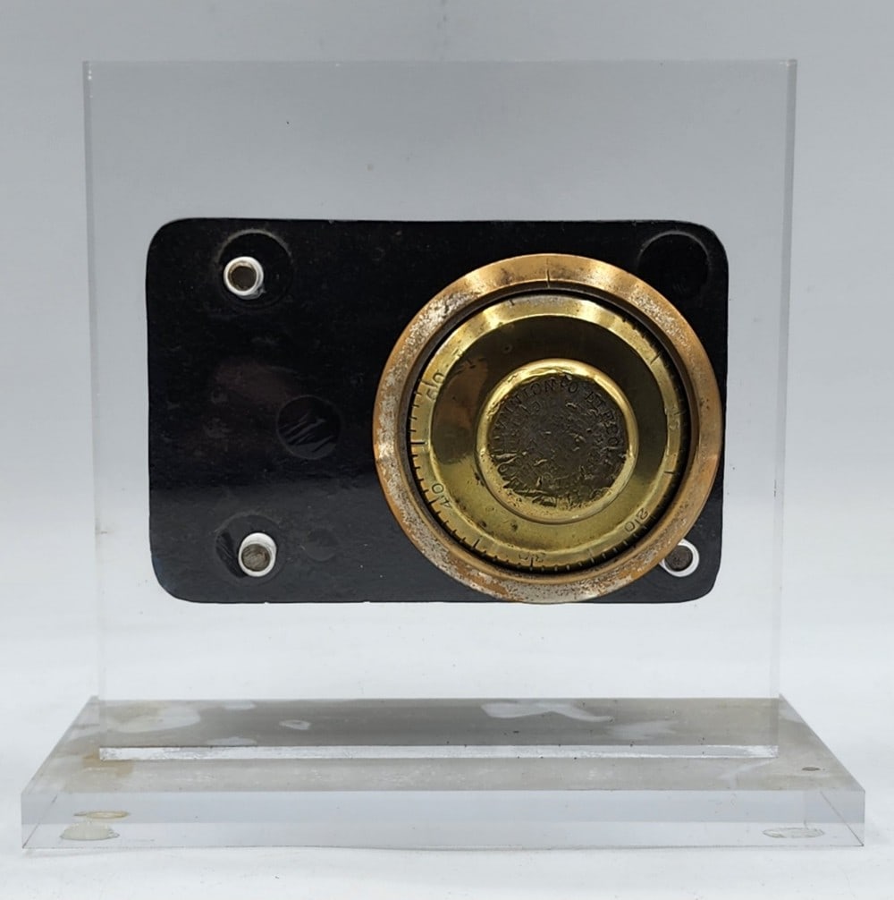 Diebold & Kienzle Safe Combination Lock Mechanism Acrylic Display: Diebold & Kienzle is a company from Cincinnati, Ohio. The safe lock was first patented February 19, 1865. It features a brass dial combination lock. Metal is worn and showing age. Measures approximate