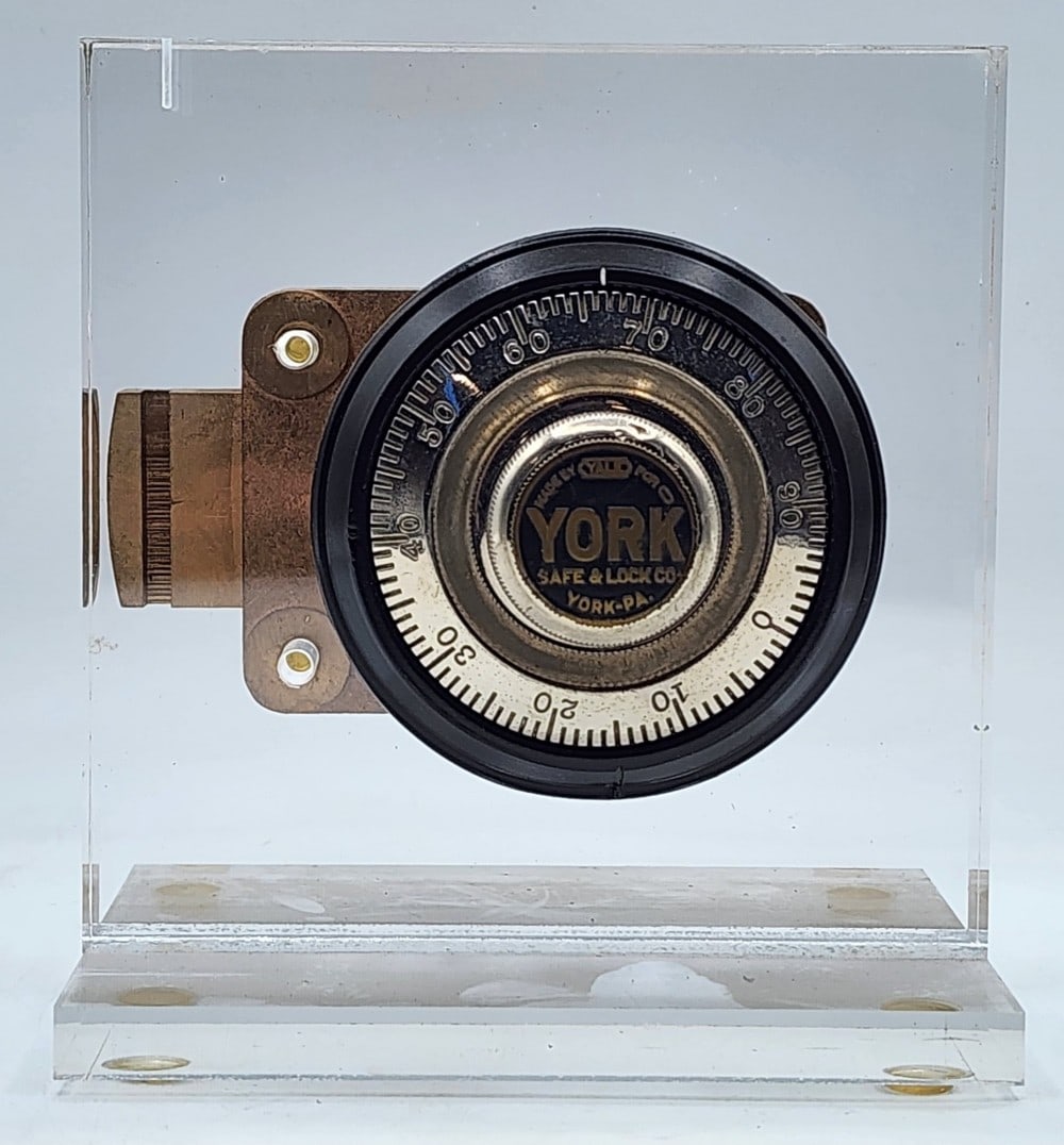 Yale Combination Lock Mechanism Acrylic Display: MMade by Yale for York Safe & Lock Co York-PA. The mechanism has a cast metal body. Small scuffs in metal due to age and use. Measures approximately 6" X 5" X 6_"